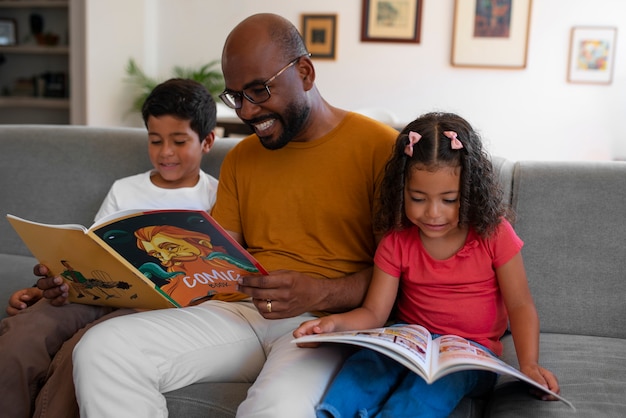 Hombre de tiro medio y niños leyendo cómics en casa.