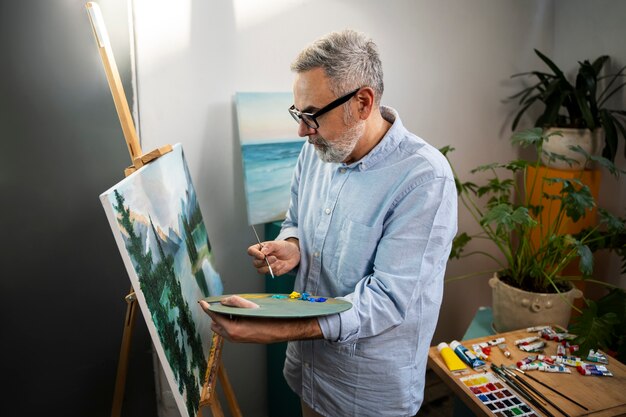 Hombre de tiro medio pintando acuarelas