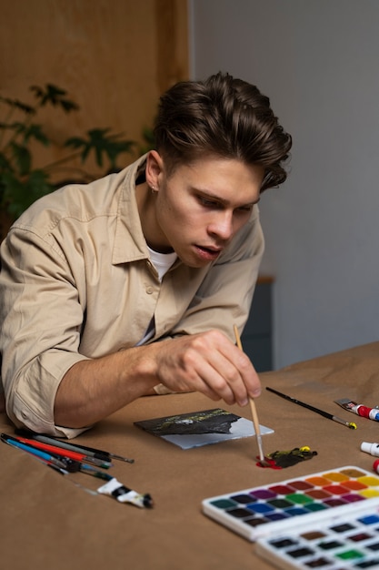 Foto gratuita hombre de tiro medio pintando acuarelas