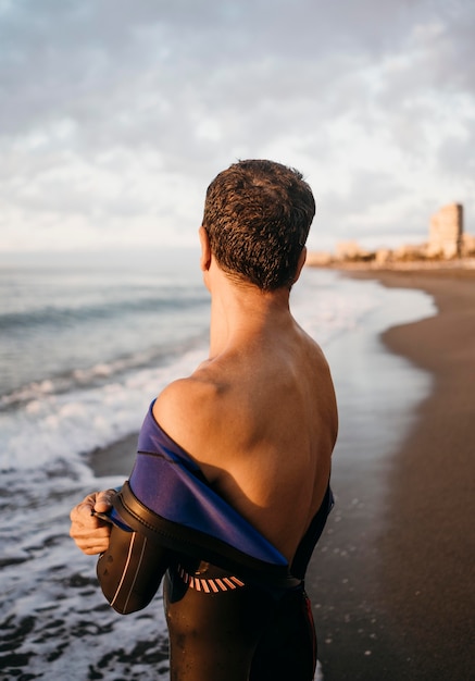 Hombre de tiro medio poniéndose traje