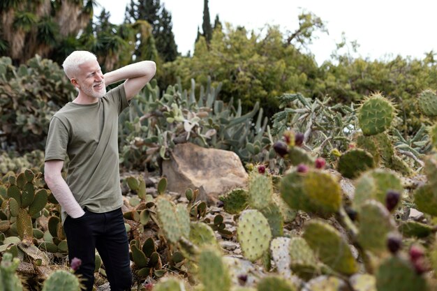 Hombre de tiro medio posando con cactus