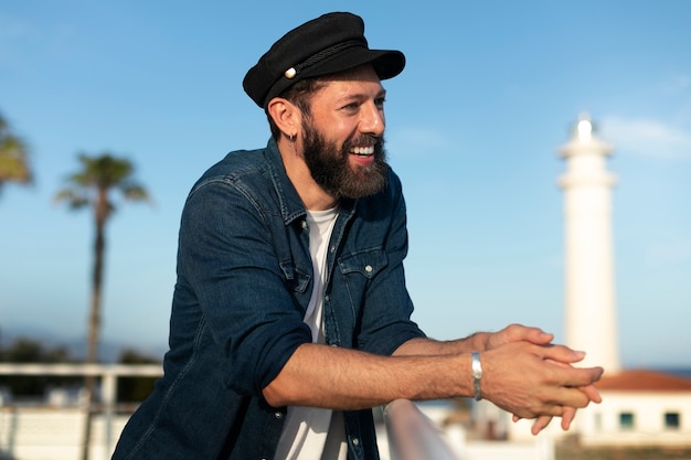 Hombre de tiro medio posando en el faro.