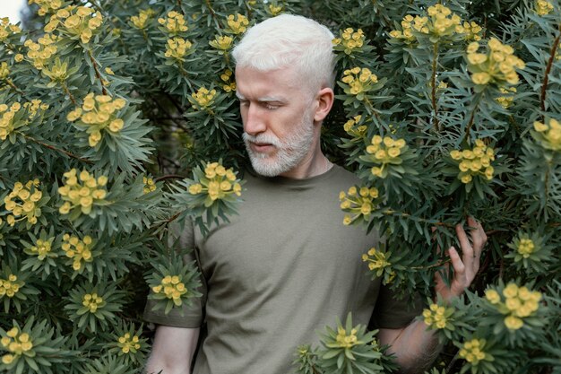 Hombre de tiro medio posando con flores