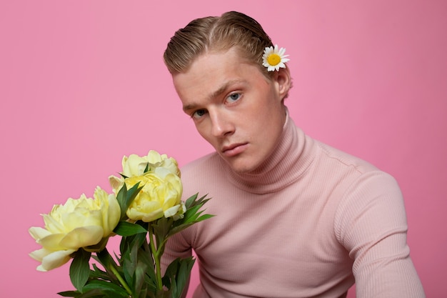 Hombre de tiro medio posando con flores