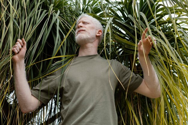 Hombre de tiro medio posando con planta