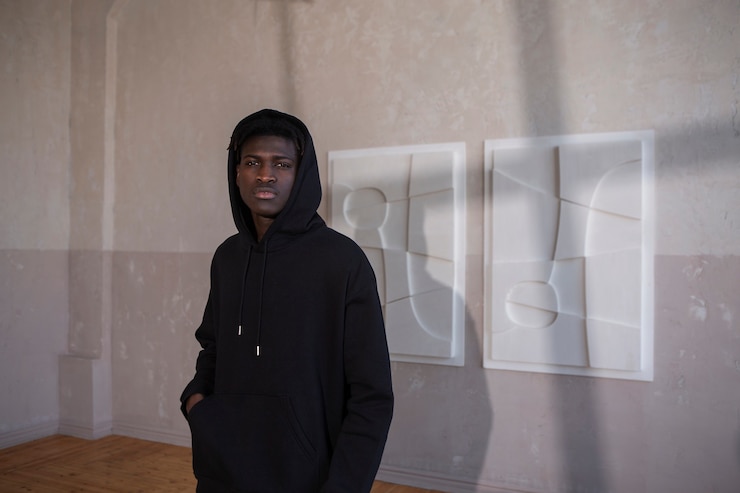 Foto gratuito hombre de tiro medio posando con sudadera con capucha dentro