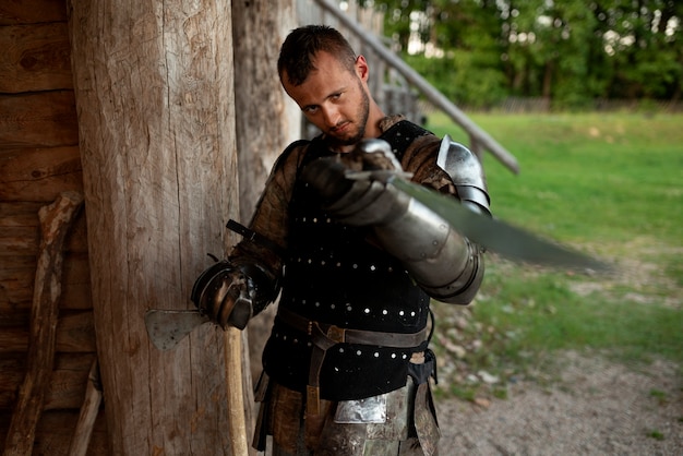 Foto gratuita hombre de tiro medio que se hace pasar por un soldado medieval