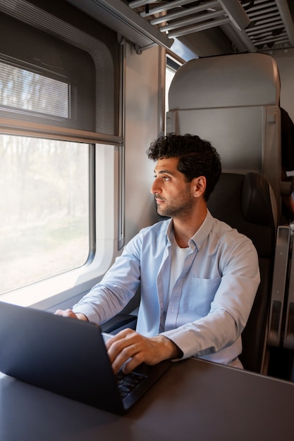 Hombre de tiro medio que viaja en tren