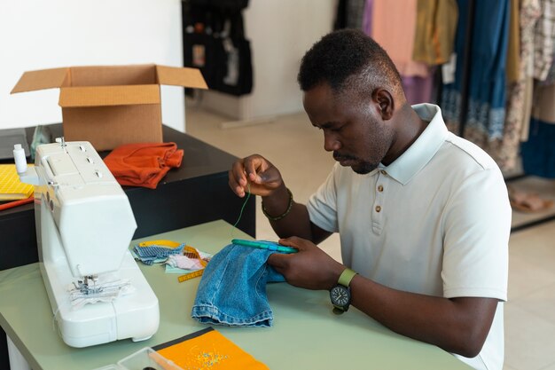 Hombre de tiro medio reparando artículos de moda.