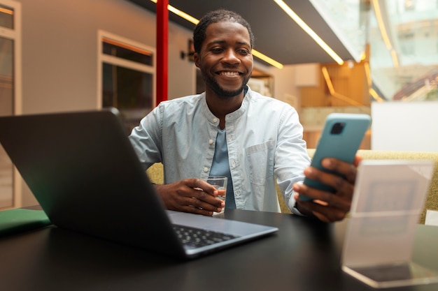 Foto gratuita hombre de tiro medio en restaurante con teléfono inteligente