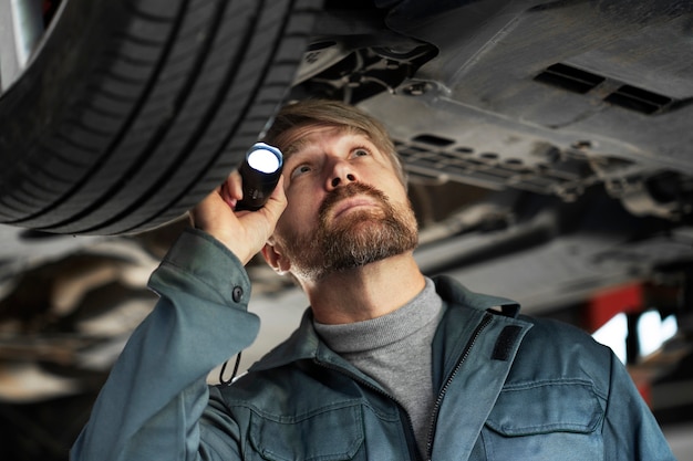 Hombre de tiro medio revisando auto