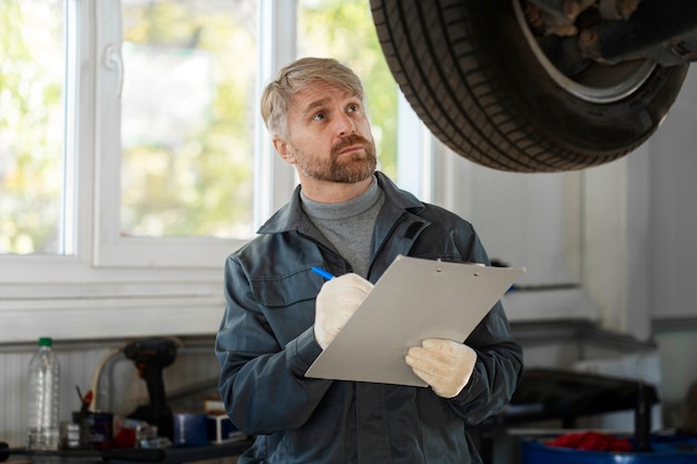 Foto gratuita hombre de tiro medio revisando auto