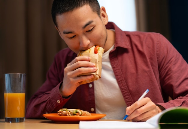 Foto gratuita hombre de tiro medio con sándwich envuelto en papel