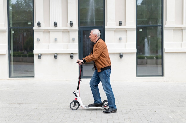 Hombre de tiro medio con scooter