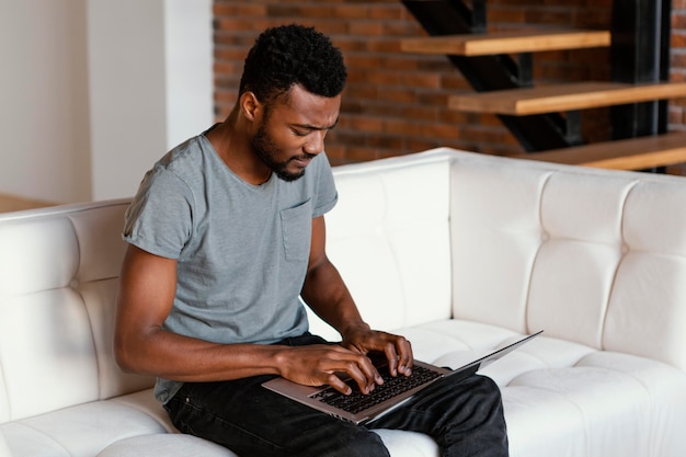 Foto gratuita hombre de tiro medio en el sofá escribiendo