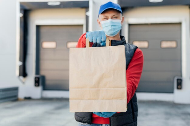 Hombre de tiro medio sosteniendo una bolsa de papel