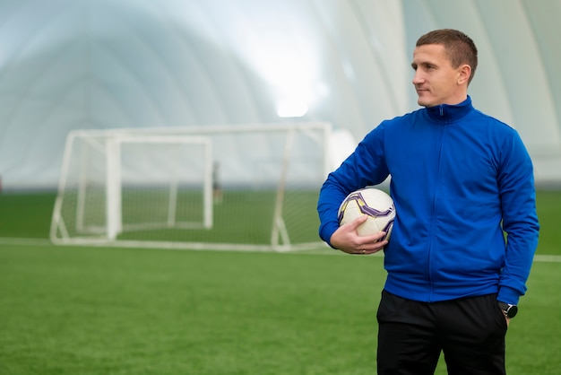 Hombre de tiro medio sosteniendo pelota