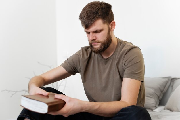 Hombre de tiro medio sosteniendo la sagrada biblia