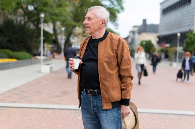 Hombre de tiro medio sosteniendo la taza de café