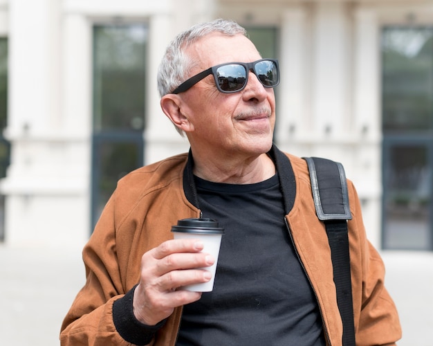 Hombre de tiro medio sosteniendo la taza de café