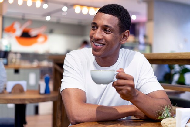 Hombre de tiro medio sosteniendo la taza de café