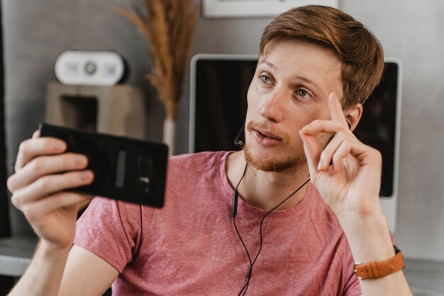 Hombre de tiro medio streaming con teléfono