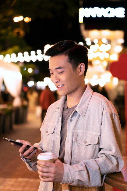 Hombre de tiro medio sujetando la taza y el teléfono