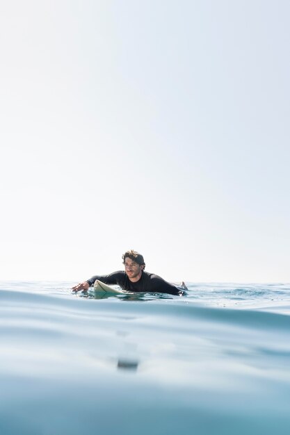 Hombre de tiro medio con tabla de surf