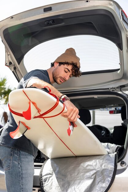 Hombre de tiro medio con tabla de surf