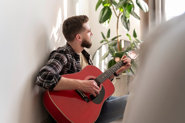 Hombre de tiro medio tocando la guitarra