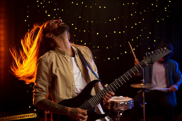 Hombre de tiro medio tocando la guitarra