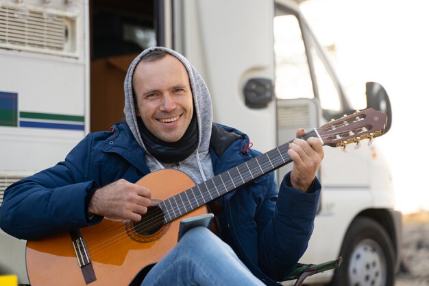 Hombre de tiro medio tocando la guitarra