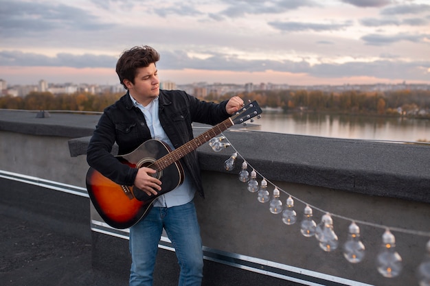 Foto gratuita hombre de tiro medio tocando la guitarra