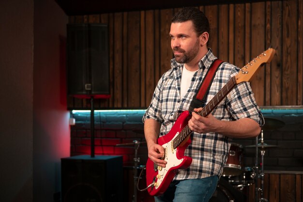 Foto gratuita hombre de tiro medio tocando la guitarra