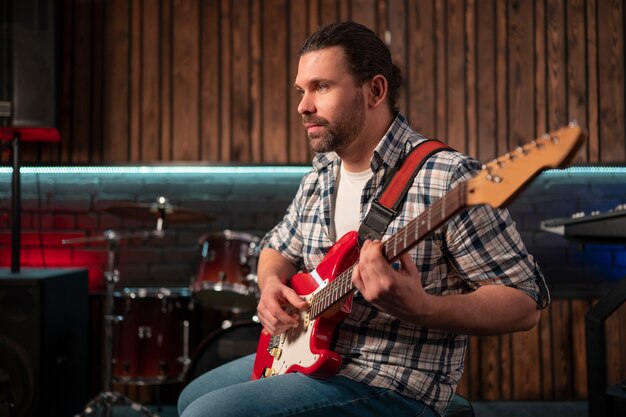 Foto gratuita hombre de tiro medio tocando la guitarra