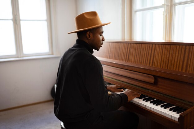 Hombre de tiro medio tocando el piano