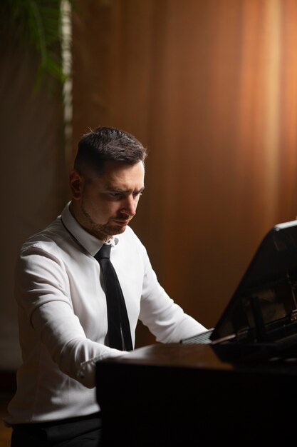 Hombre de tiro medio tocando el piano