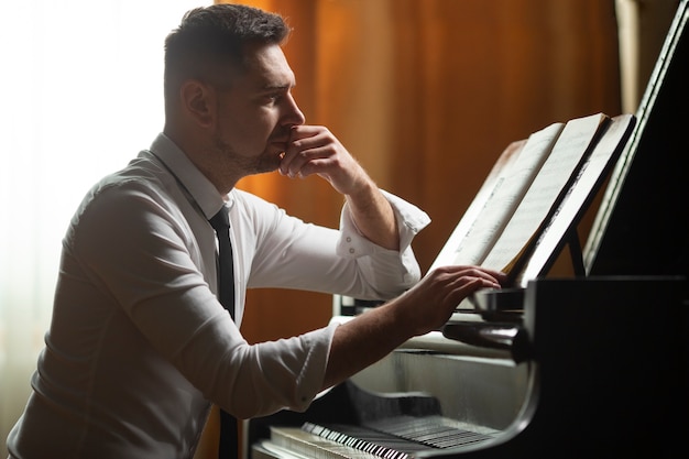 Hombre de tiro medio tocando el piano