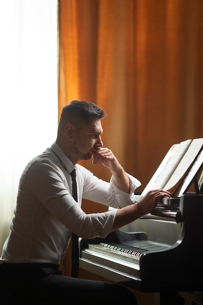 Hombre de tiro medio tocando el piano