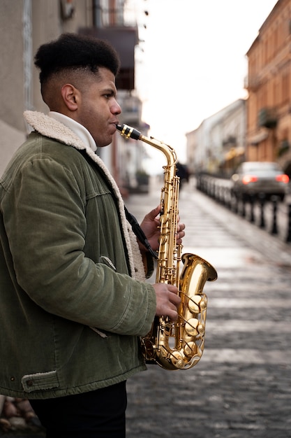 Foto gratuita hombre de tiro medio tocando el saxofón