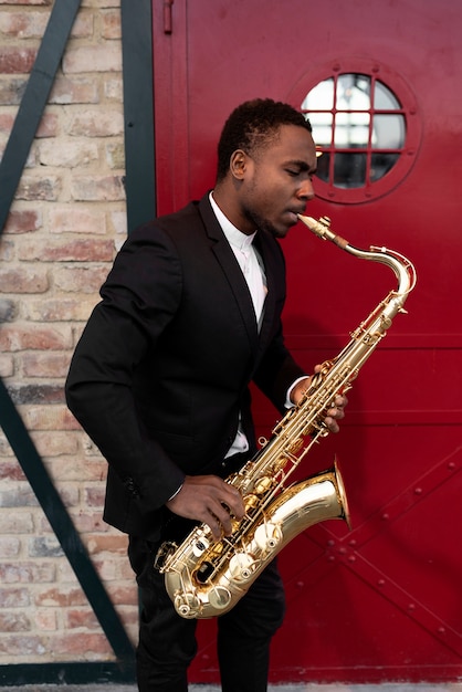 Hombre de tiro medio tocando el saxofón