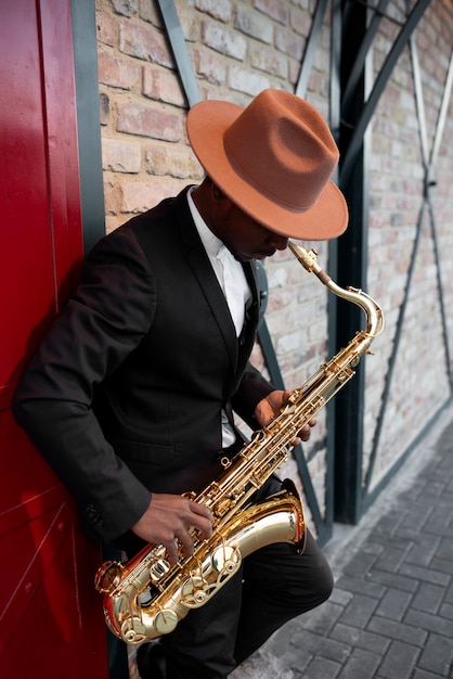 Foto gratuita hombre de tiro medio tocando el saxofón