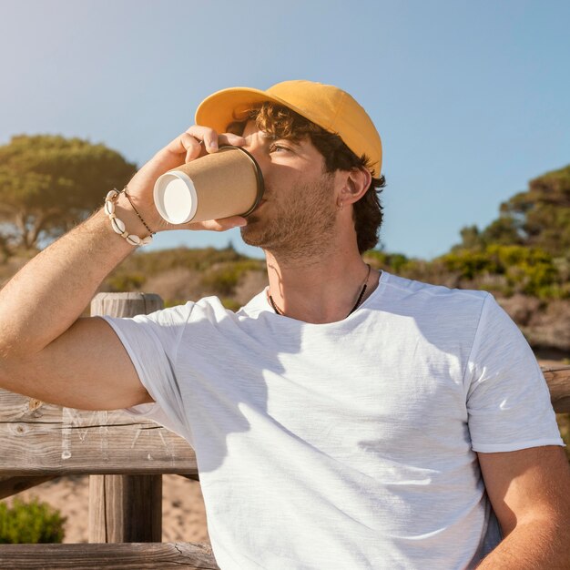 Hombre de tiro medio tomando café