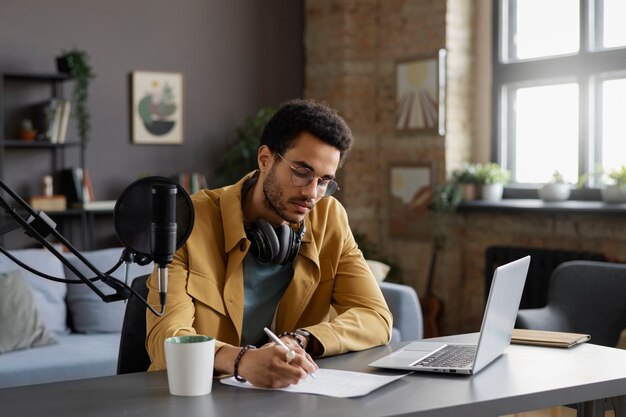 Hombre de tiro medio tomando notas para podcast