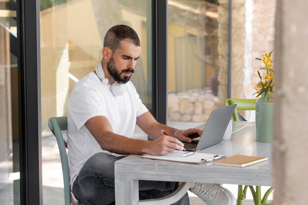 Hombre de tiro medio tomando notas