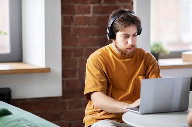 Hombre de tiro medio trabajando en la computadora portátil