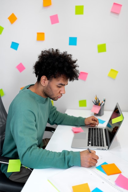 Hombre de tiro medio trabajando con computadora portátil