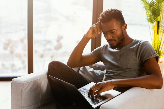 Hombre de tiro medio trabajando en el sofá