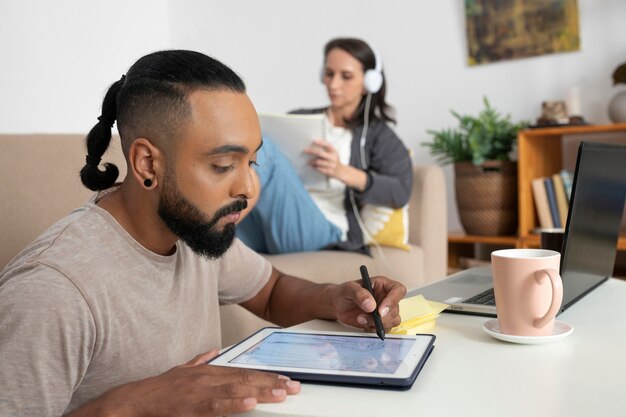 Hombre de tiro medio trabajando en tableta