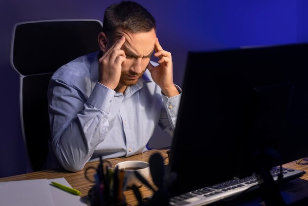 Hombre de tiro medio trabajando tarde en la noche